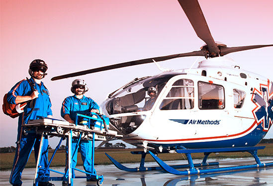 Pilots standing in front of helicopter