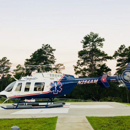 air medical helicopter on landing pad near trees