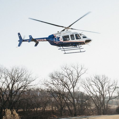 air medical helicopter flying alone over trees