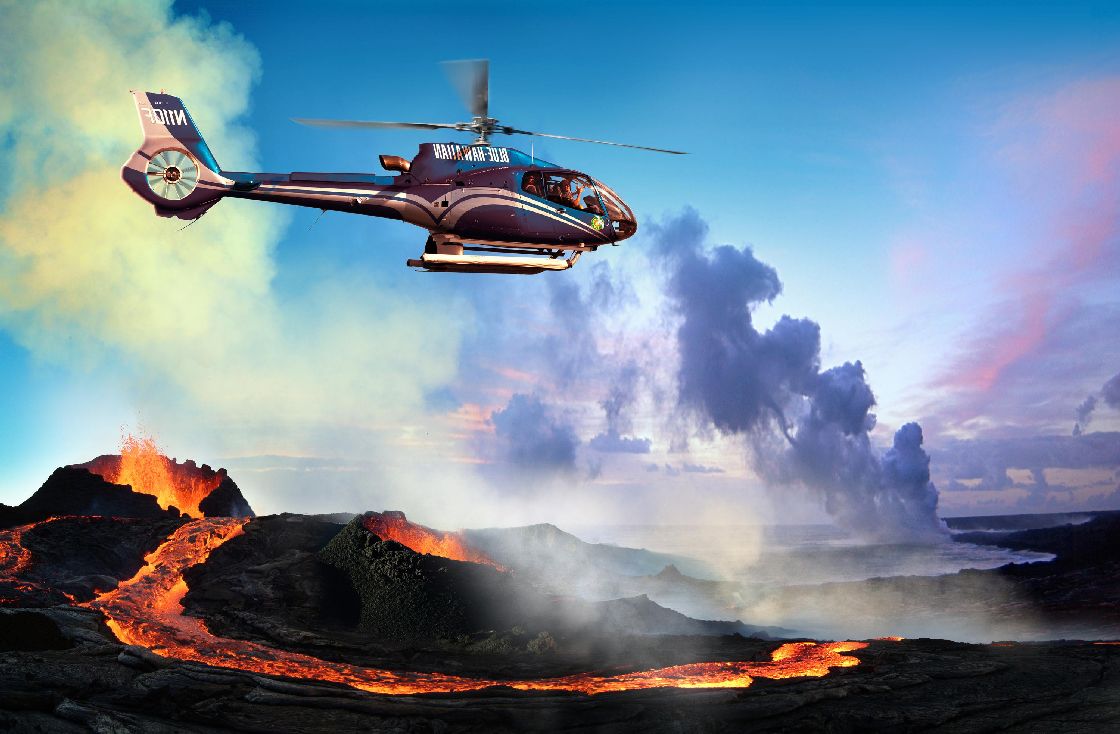 Blue Hawaiian helicopter flying over volcano. 